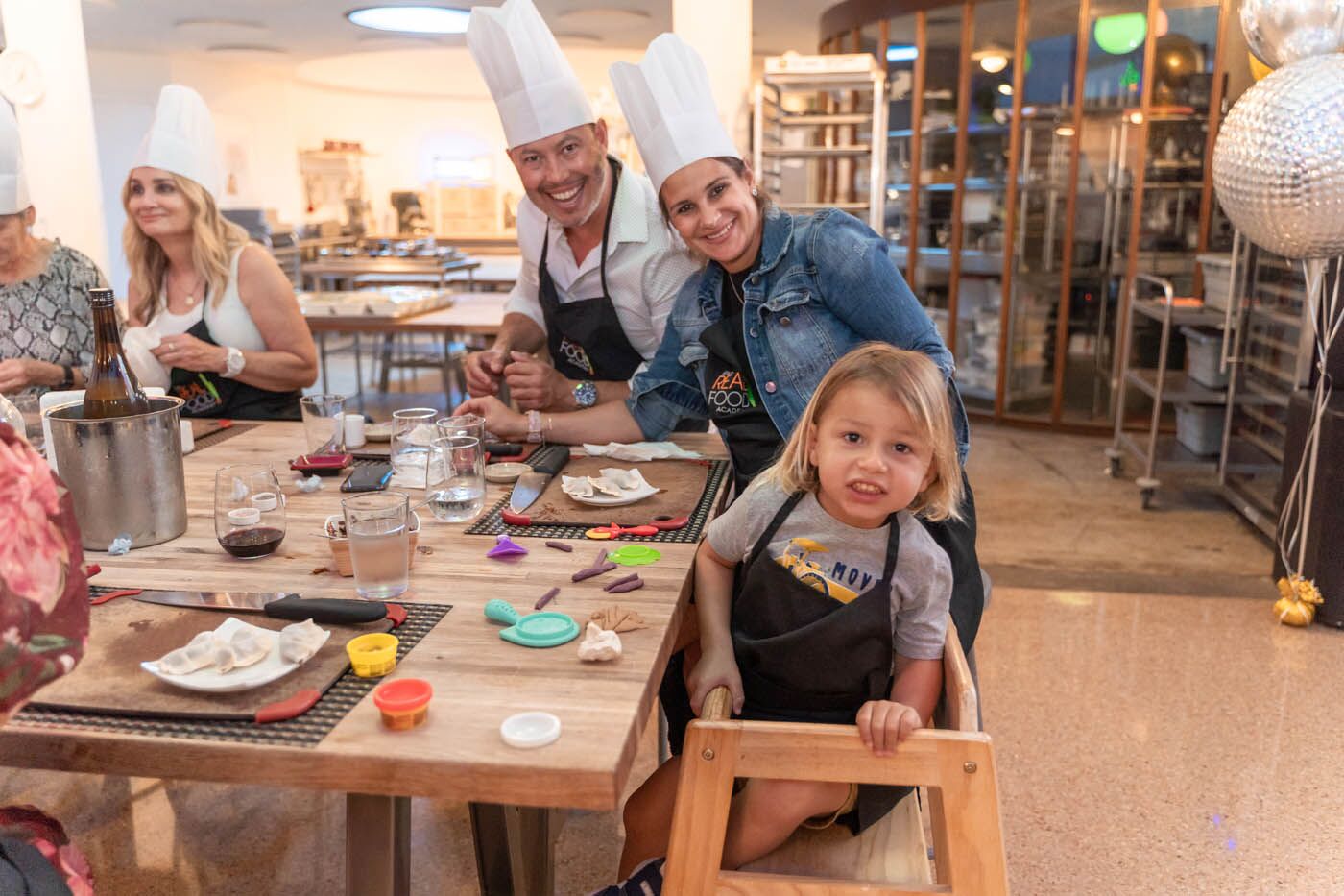 A family with a little boy eating at The Real Food Academy's birthday party celebration places.