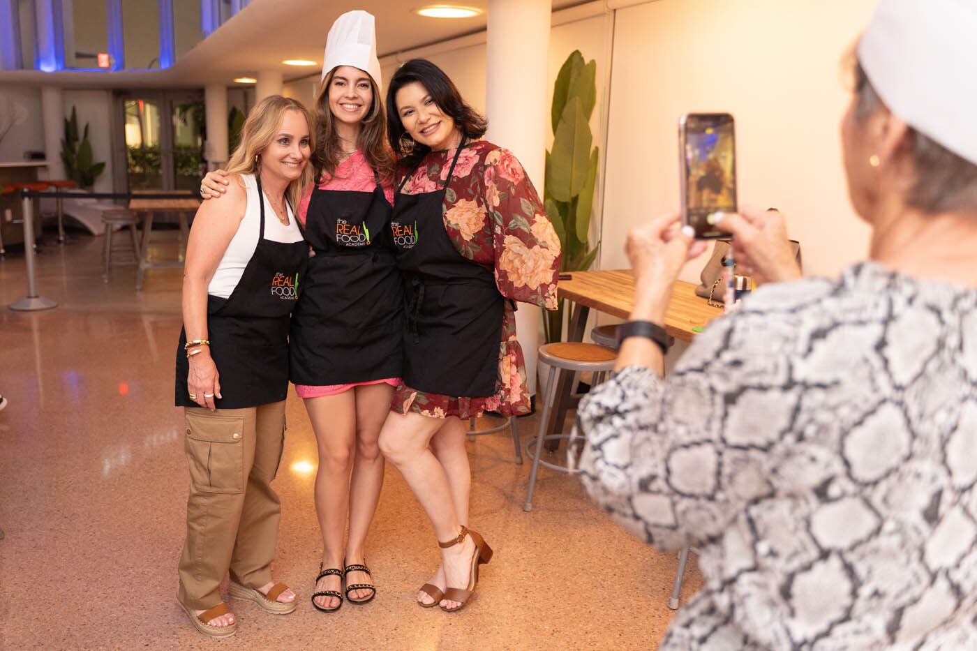 A group of girlfriends smiling at a private event in The Real Food Academy Miami, FL.