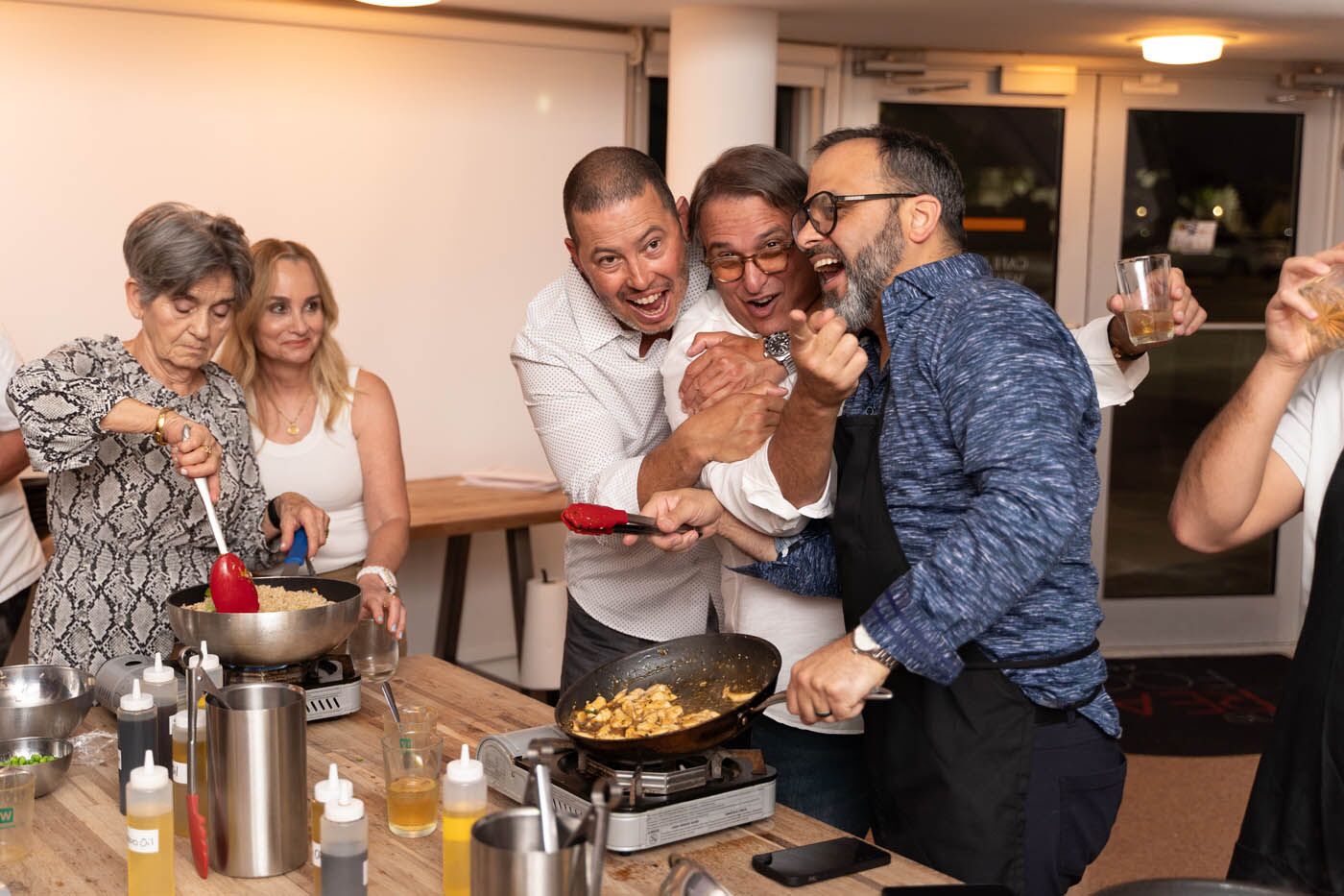 A group of men laughing during their team building activity in Miami, FL at The Real Food Academy.
