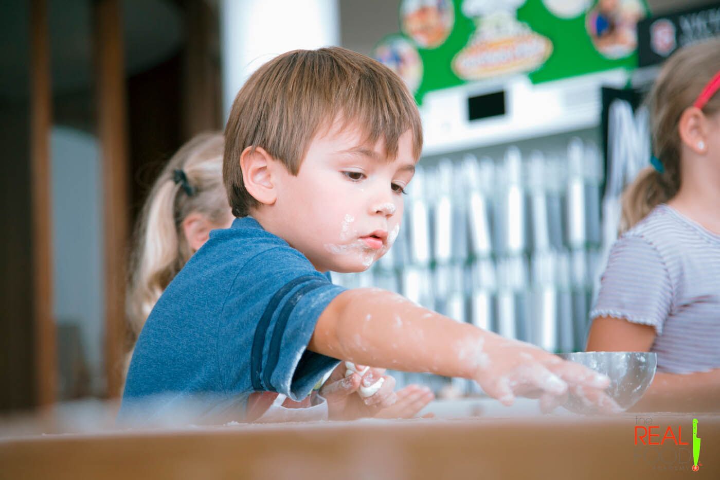 A little kid with flower on his face practicing his cooking skills at The Real Food Academy's after school program in Orlando, FL.