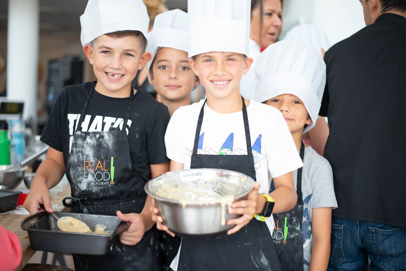 A young boy holding a mixing bowl at The Real Food Academy Miami's cooking class for teens.