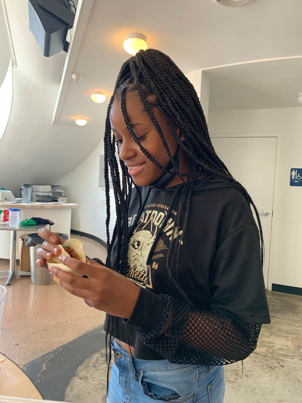 A young girl enjoying a fresh taco at The Real Food Academy Miami cooking classes for teens.
