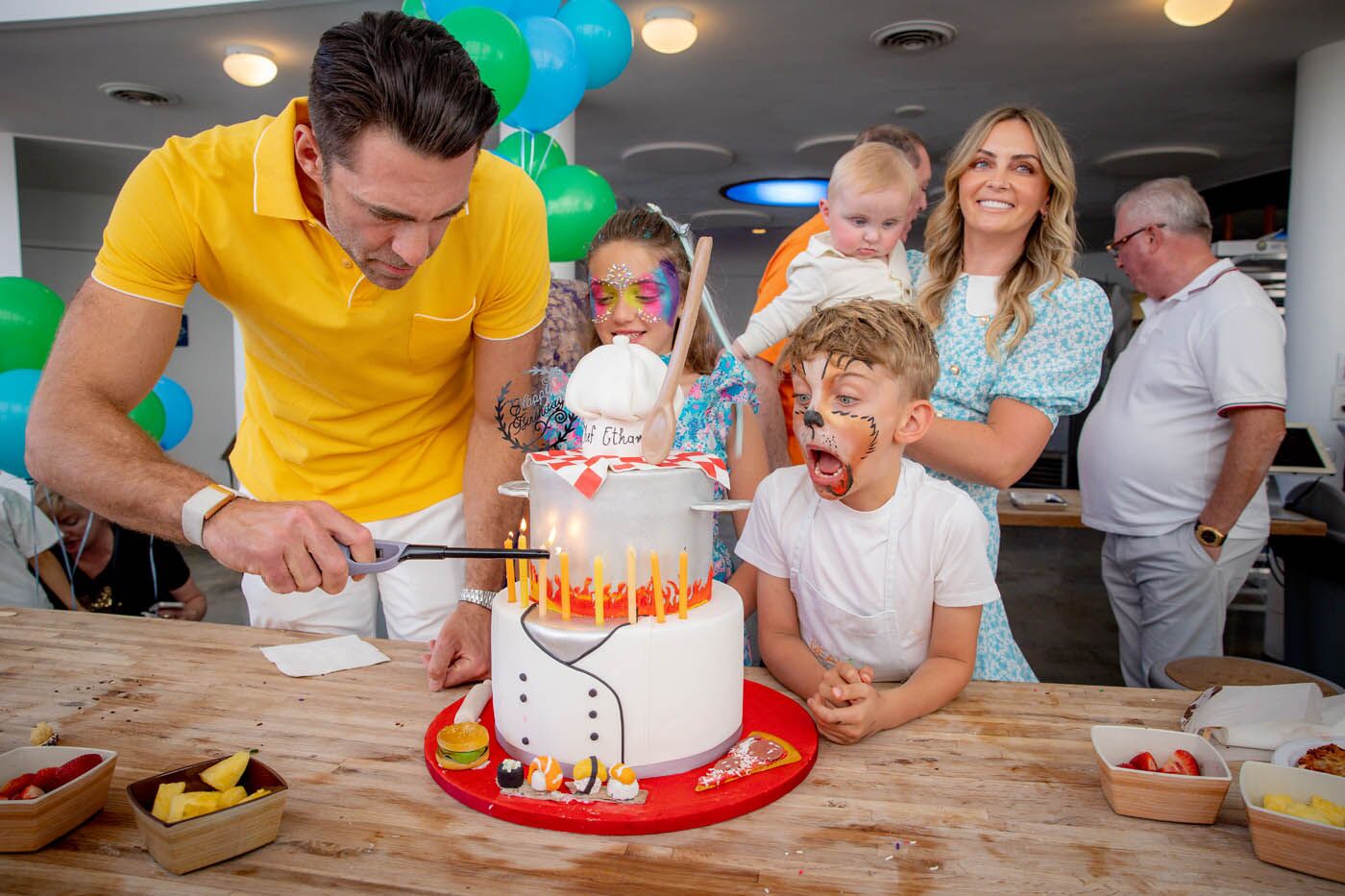 A parent cutting a cake at The Real Food Academy Miami party.