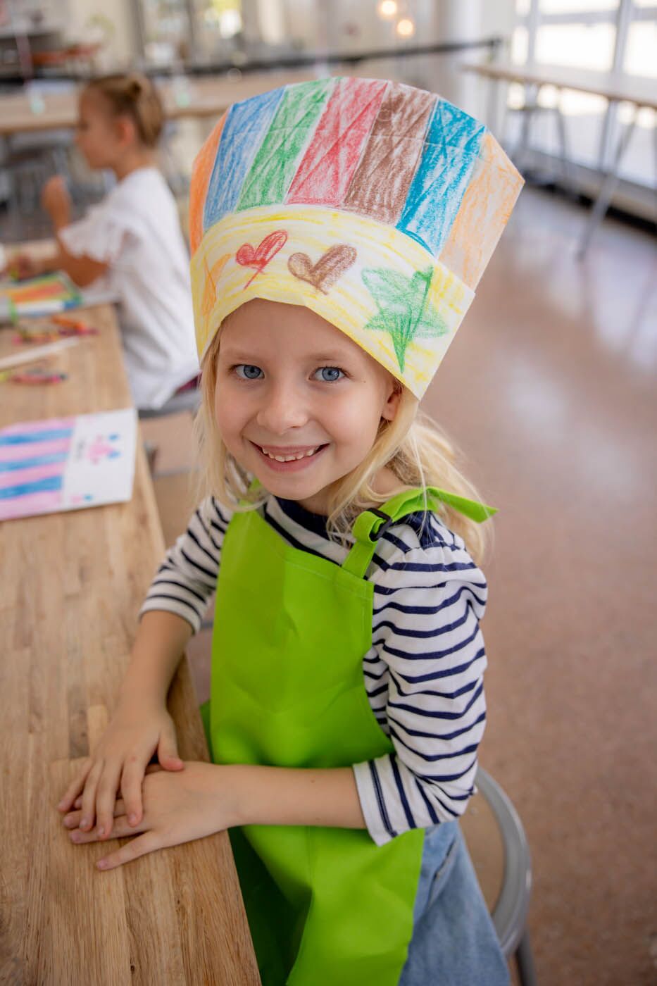 A little kid with a rolling pin and a kids cooking birthday party.