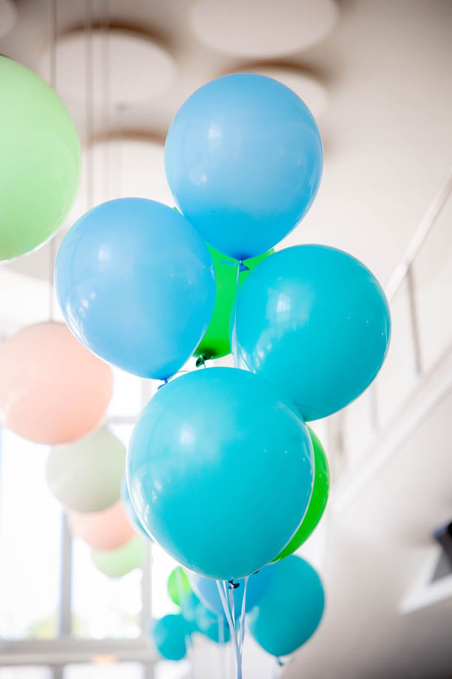 A bunch of blue baloons at an indoor birthday party.