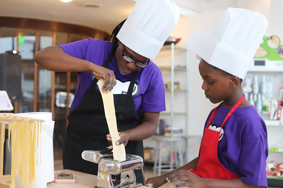 A mom and son rolling fresh pasta at The Real Food Academy Miami, FL.