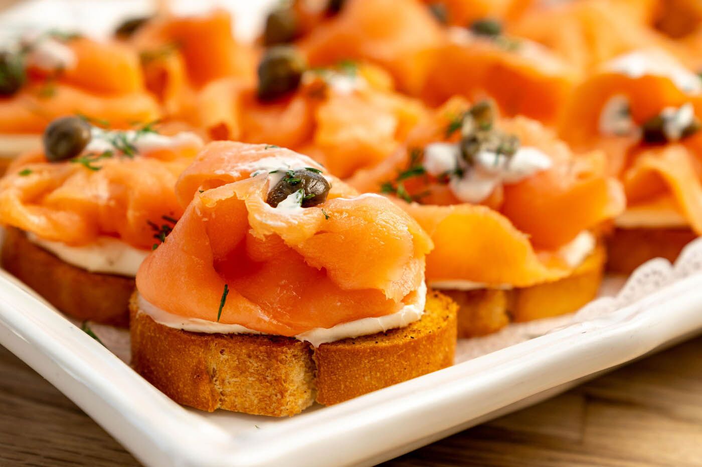 Smoked salmon with a side of capers in a white plate at The Real Food Academy Miami.