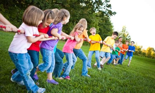 Image of kids playing tug of war at a birthday party outside