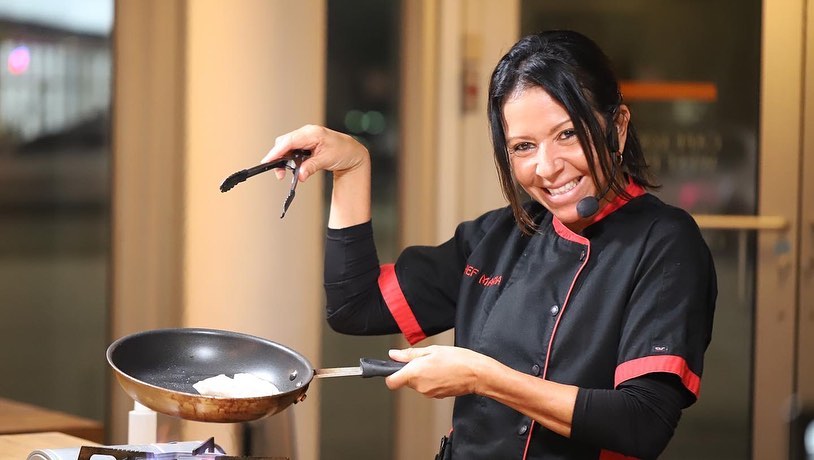 Chef Maria Cummins at The Real Food Academy showing off her skills with a pan - learn about the best franchise opportunity in your local area, FL