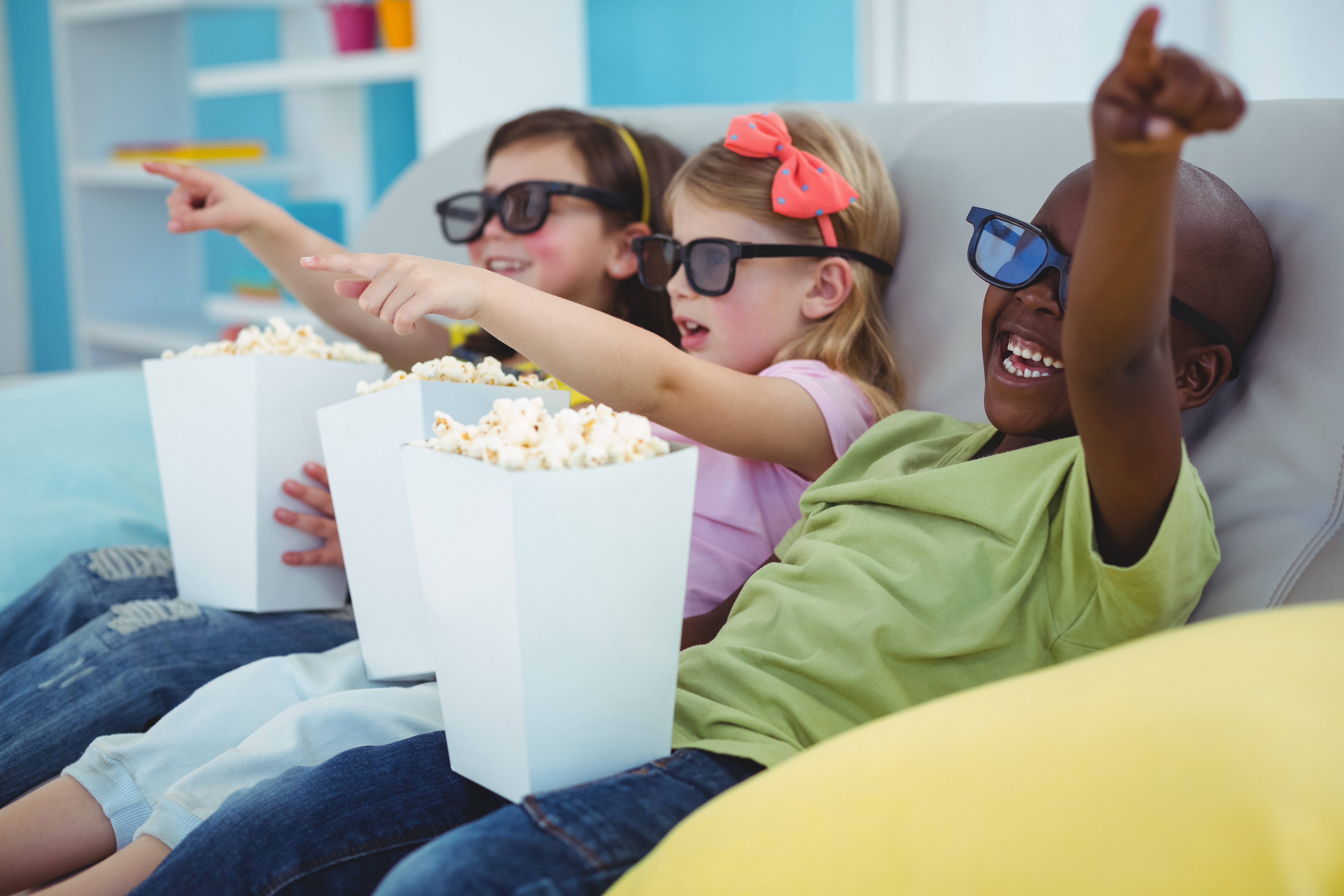 A group of kids watching a movie for a birthday party.