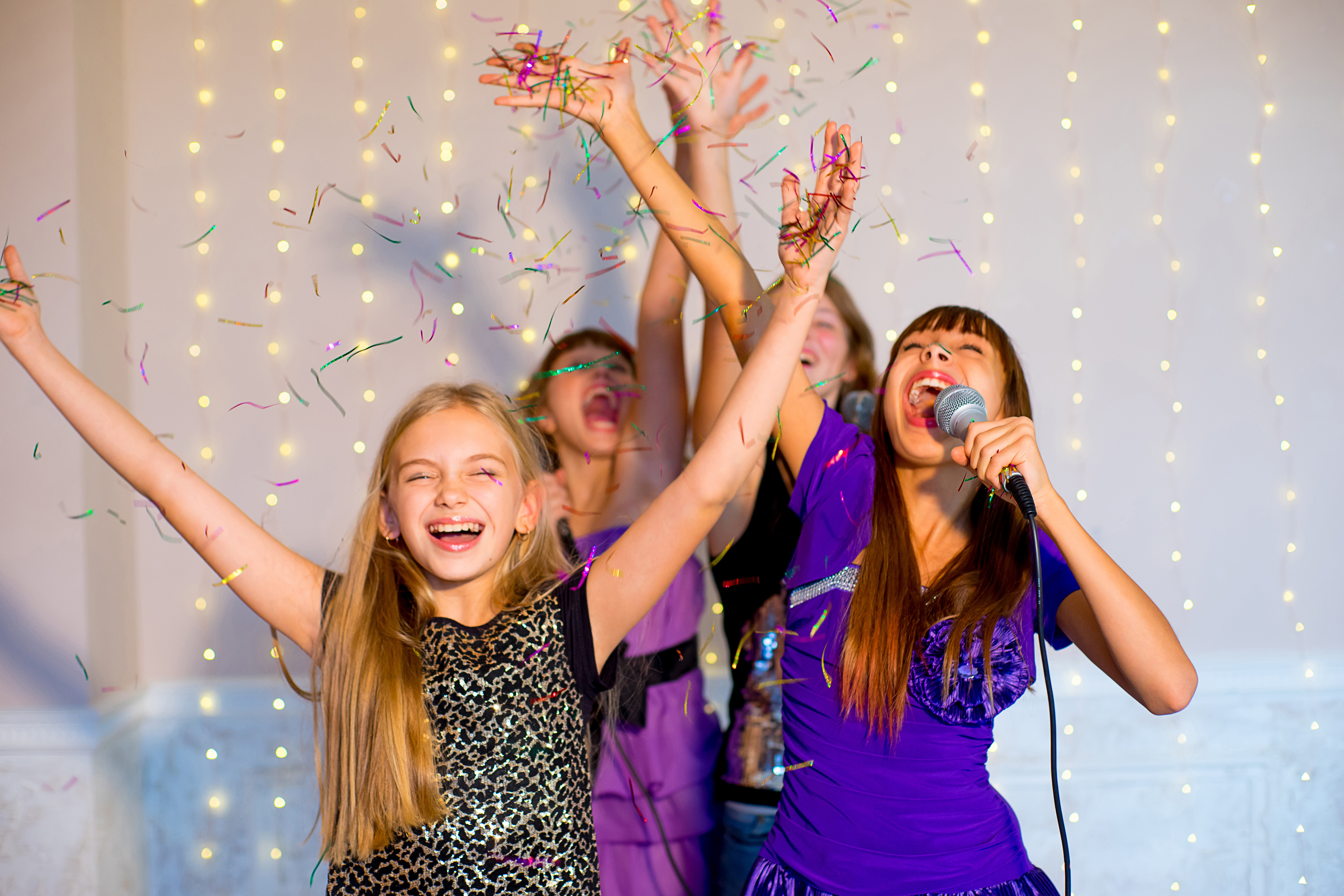 A group of kids singing karaoke at a music themed party, inspired by The Real Food Academy.