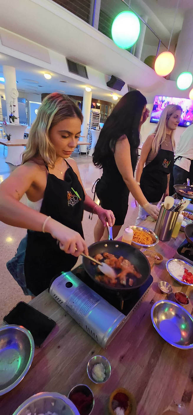A women cooking in a pan at The Real Food Academy Miami, FL's party venue.