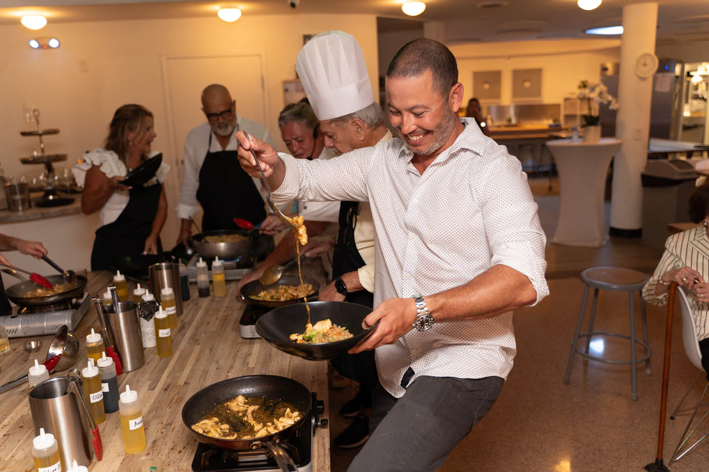 A man dancing with a fresh plate of food at The Real Food Academy's adult cooking class in Miami, FL.