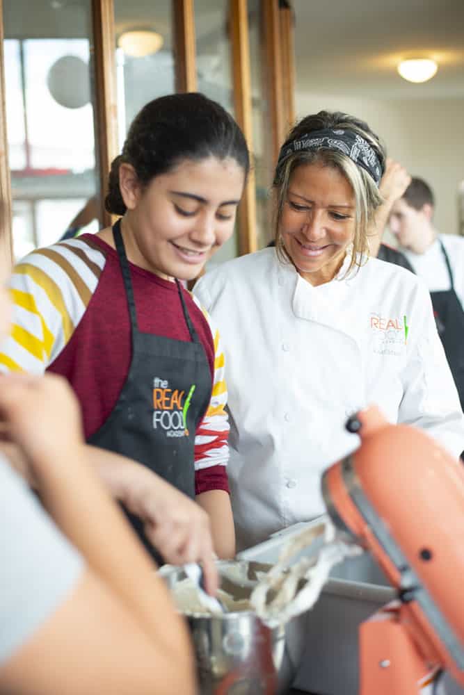 Chef Maria Cummins and a teenager cooking together at our summer camp for teens in Miami, FL.