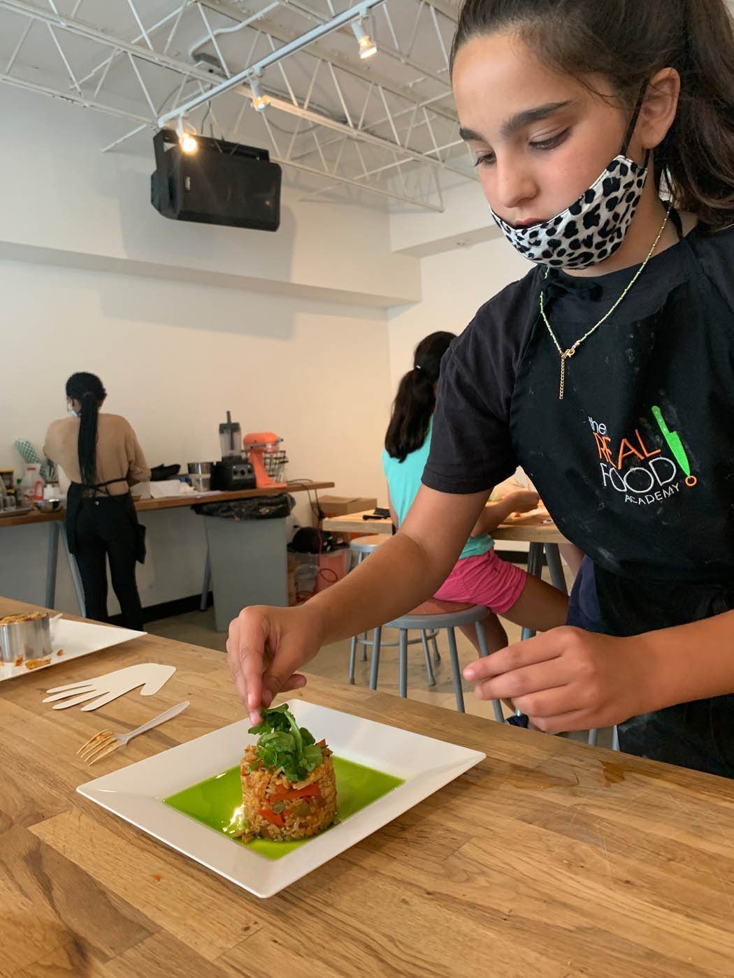 A young teen creating a delicious meal - The Real Food Academy offers summer programs for teens in Miami, FL so they can explore their creativity!