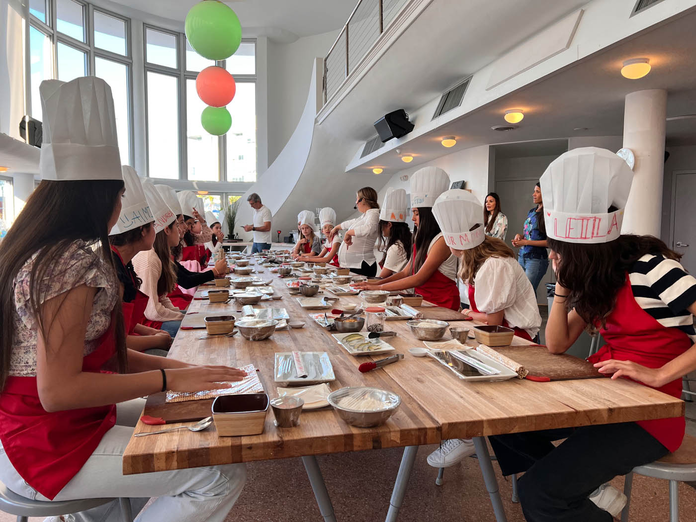 A little girl with a The Real Food Academy apron, a birthday party venue in Miami, FL.